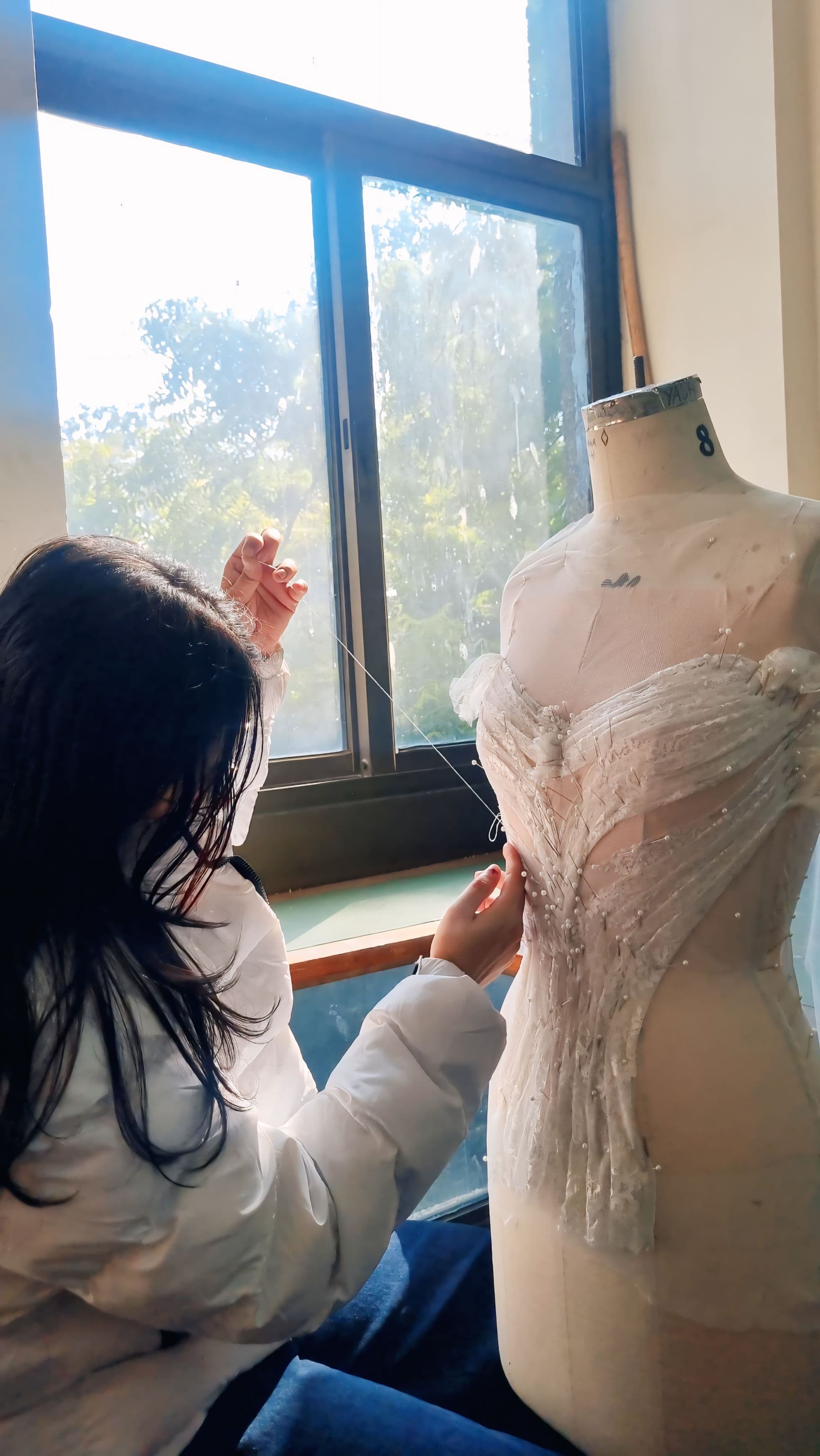 Yashnoor working on a garment form in the studio